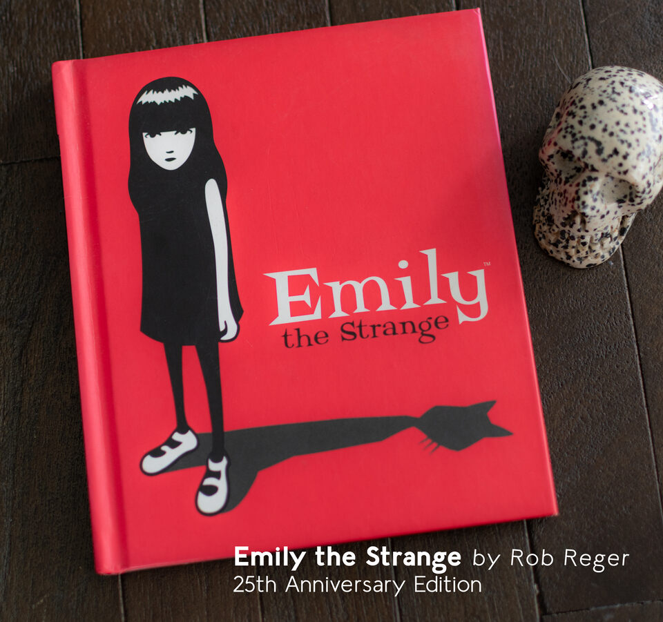 Emily the Strange 25th Anniversary Edition Book written by Rob Reger, photograph of the book on a wooden table