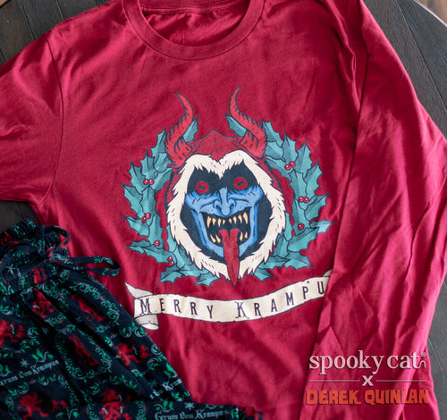 Red long sleeve Merry Krampus shirt featuring a blue-faced Krampus with horns, holly wreath, and banner text “Merry Krampus."